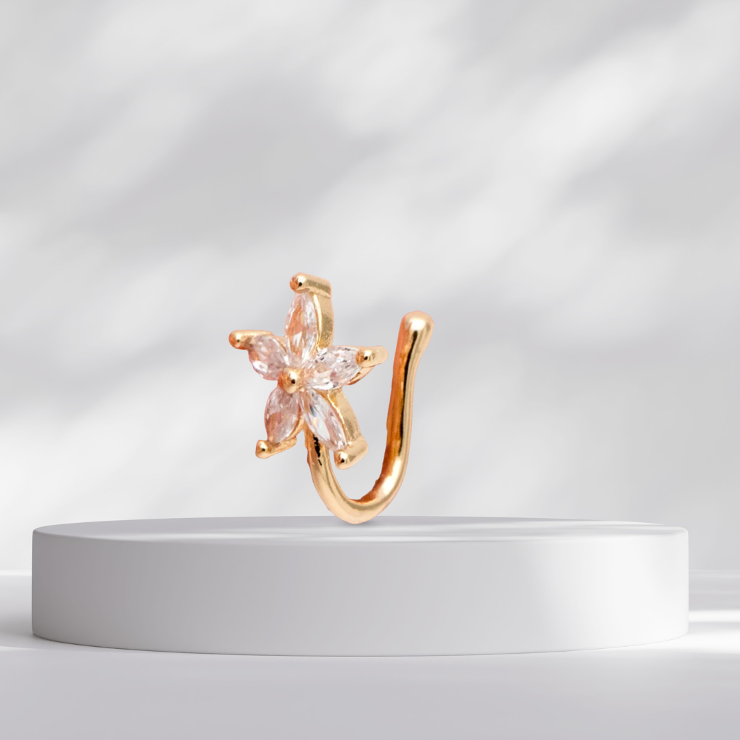 Gold star flower nose cuff on a white platform with a light gray background