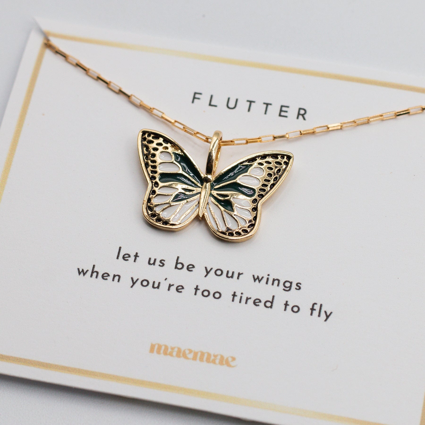 Close-up of a gold butterfly charm pendant on a delicate chain.