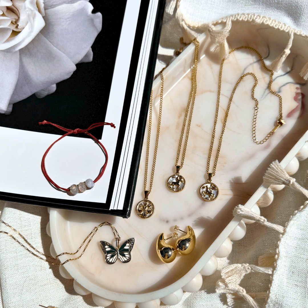 Close-up of an 18k gold zodiac necklace pendant on a delicate chain, representing a personalized astrological sign. - MaeMae Jewelry