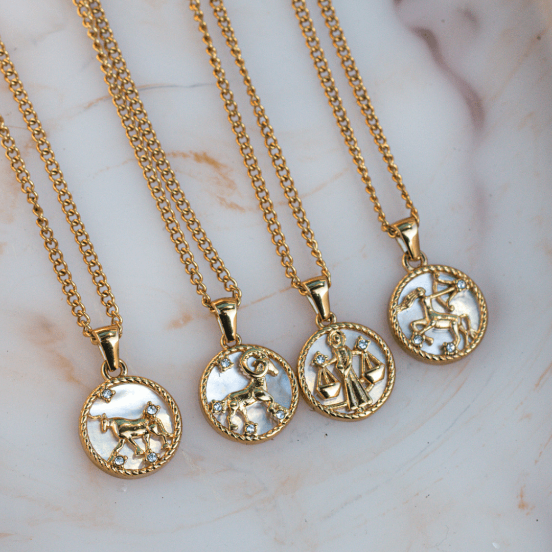 Close-up of an 18k gold zodiac necklace pendant on a delicate chain, representing a personalized astrological sign. - MaeMae Jewelry