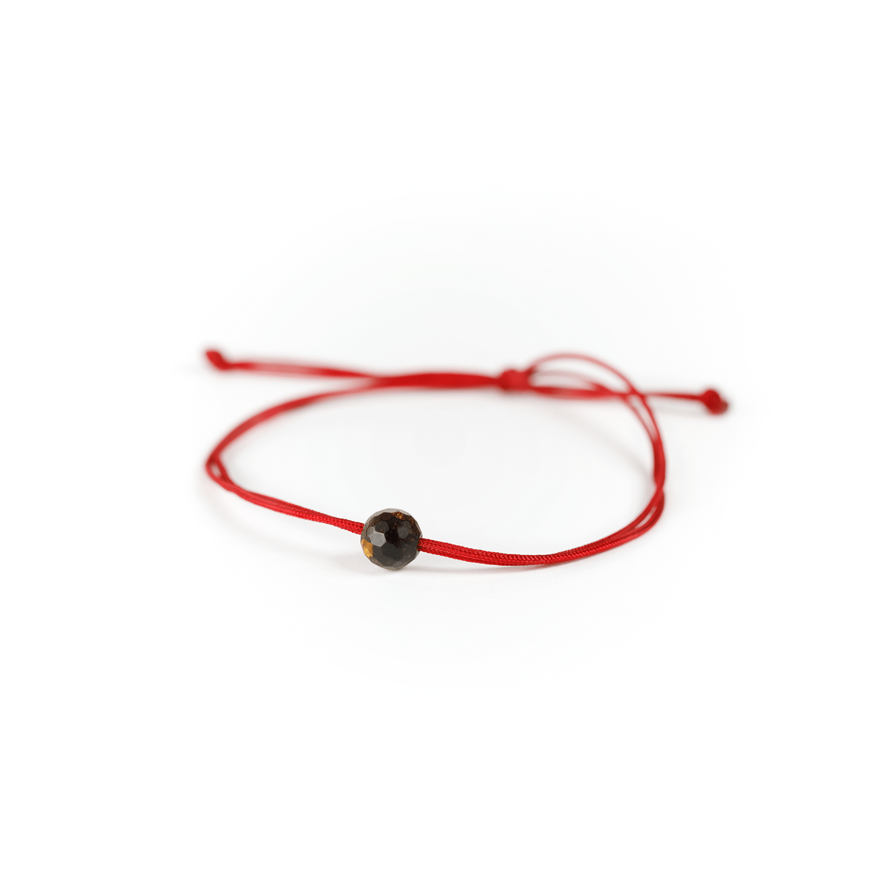 Close up of the tiger eye stone on red nylon string.