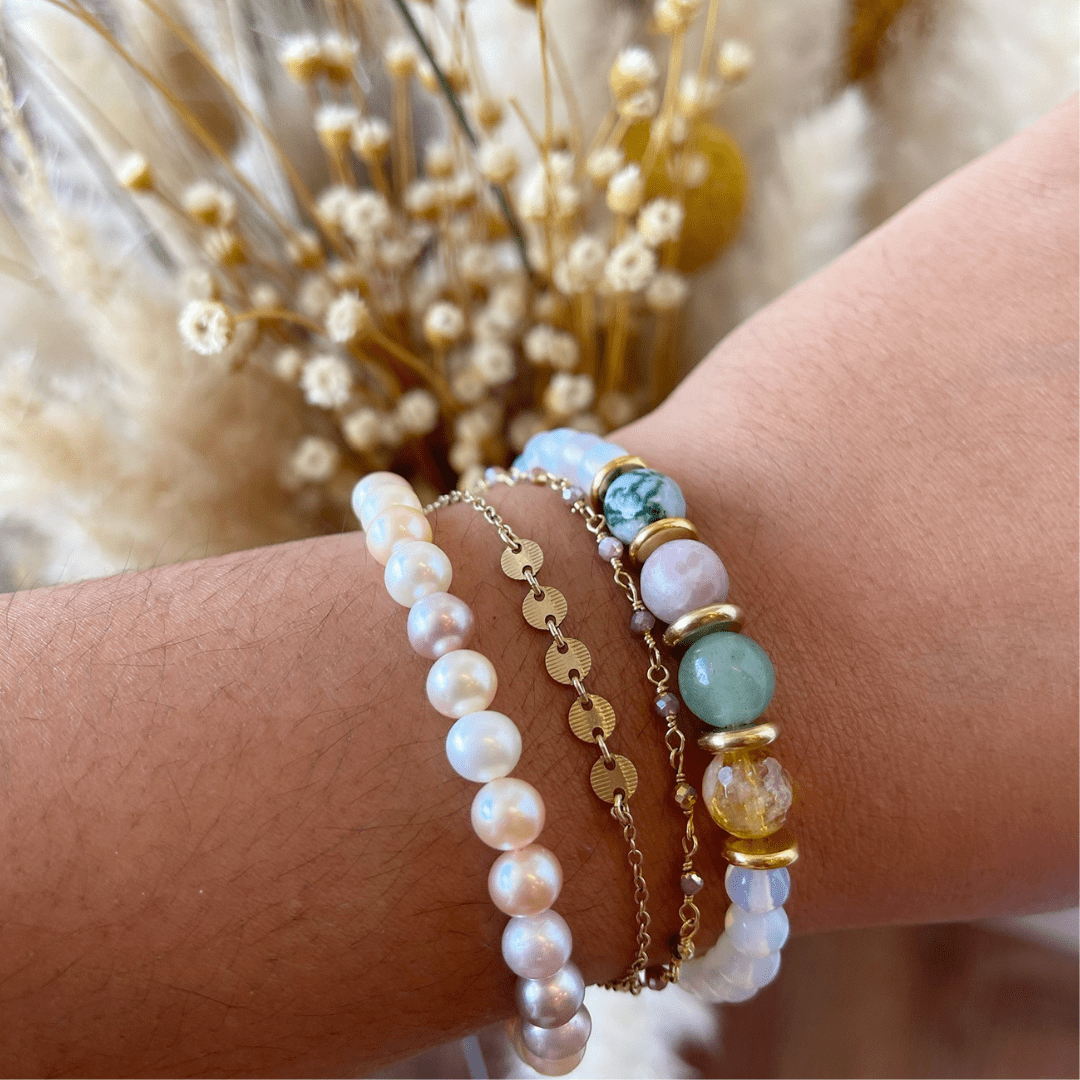 Personalized stone bracelet on a wrist, showcasing unique crystal combinations.