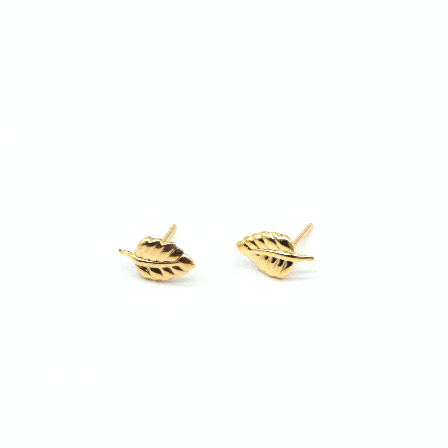 MaeMae Jewelry leaf stud earrings facing opposite directions on white background