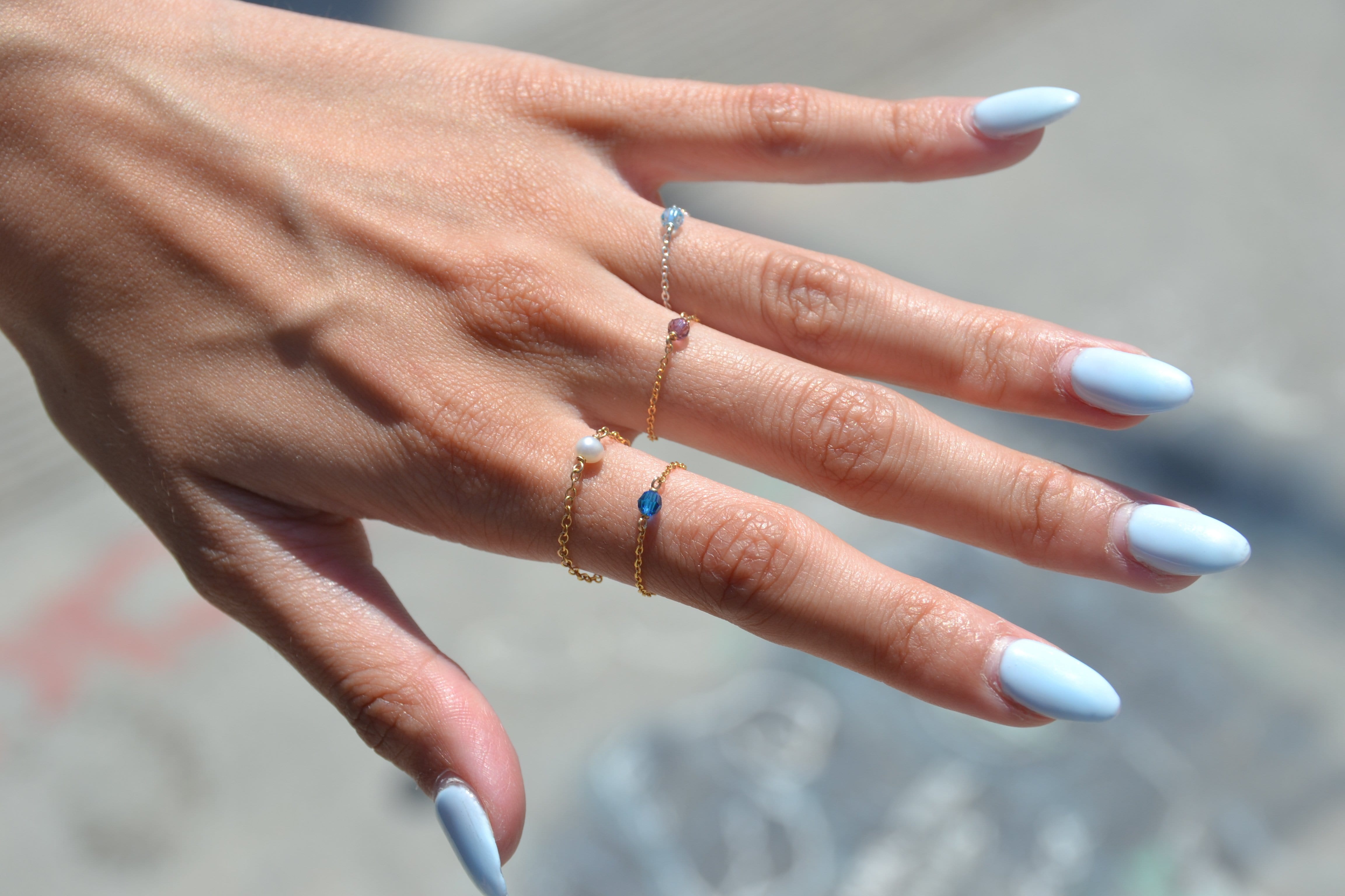 birthstone rings stacked on model's fingers