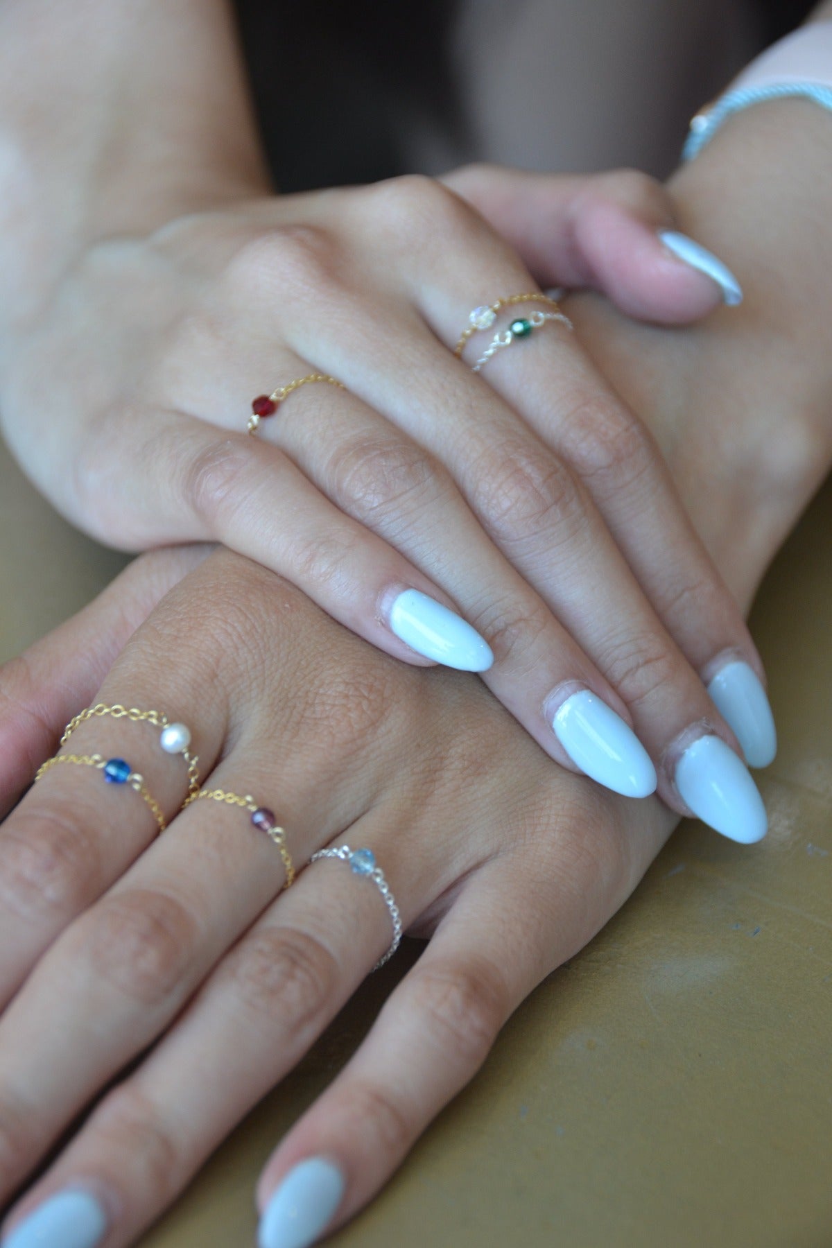 stacked birthstone rings on both model's hands