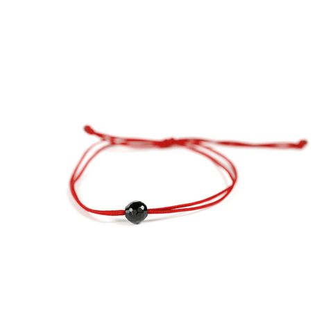 Close up of the black onyx stone on red nylon string.