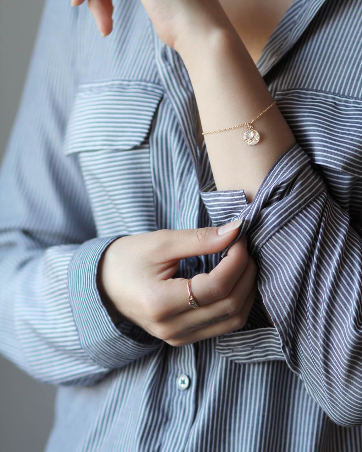 Perseverance gold bracelet worn on model's arm