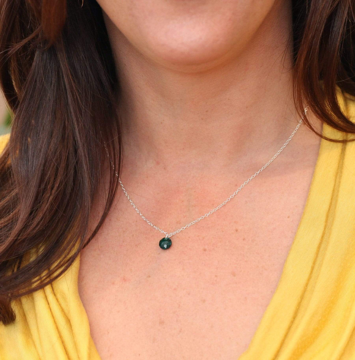 Close up view of a MaeMae Birthstone Necklace -Crystal Pendant on a delicate silver necklace chain.