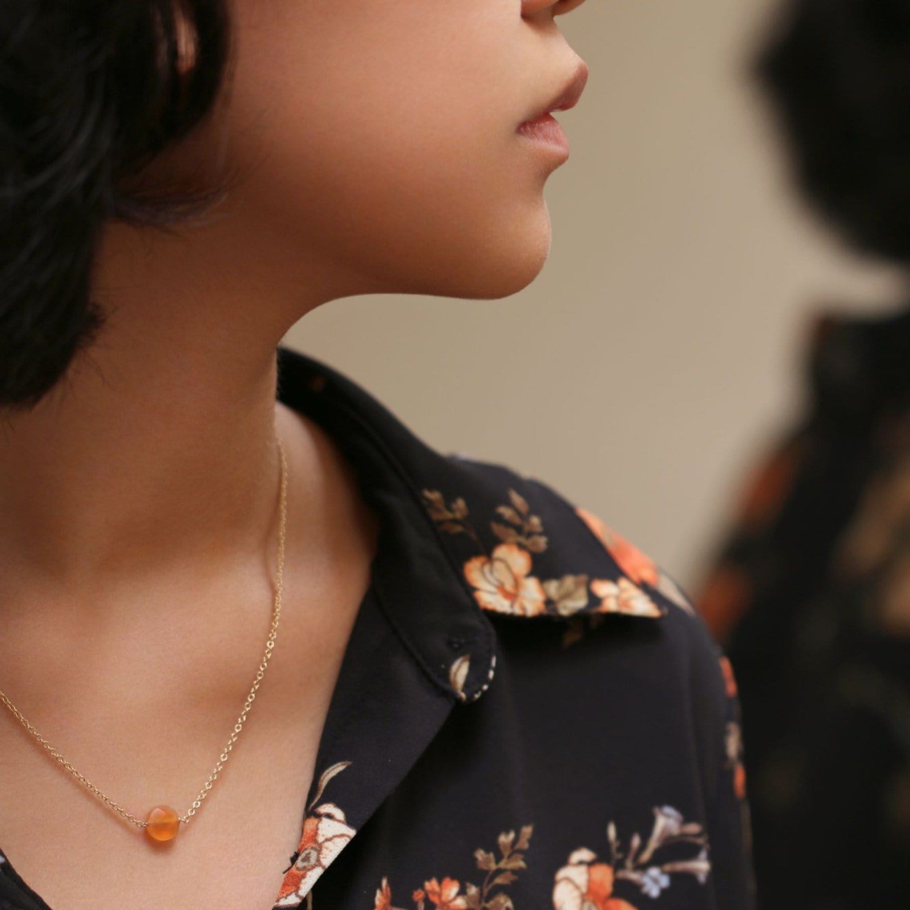 Carnelian stone on gold chain necklace worn on model