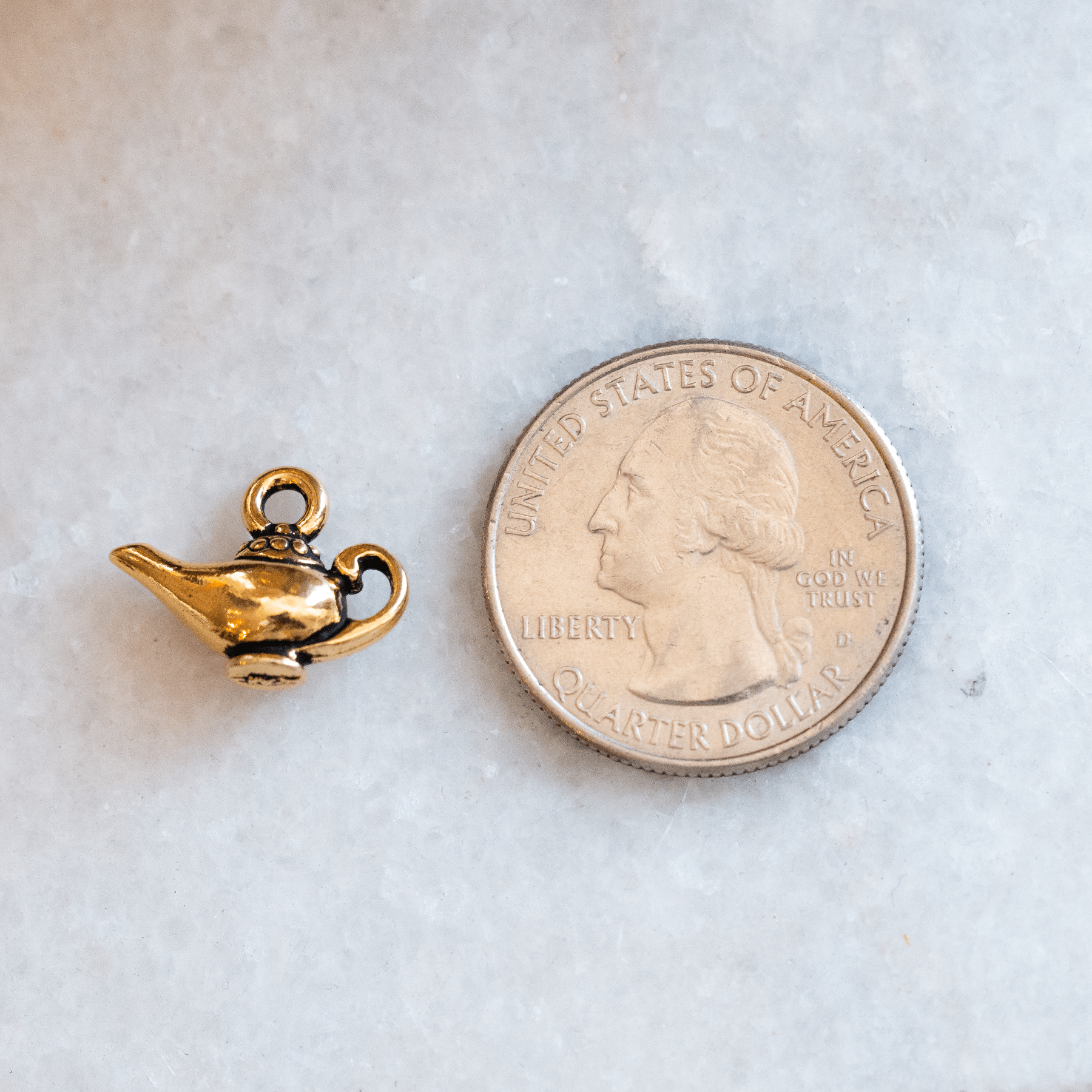 The Great genie lamp charm size comparison with quarter